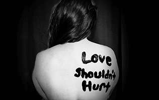 love shouldn't hurt writing on woman's back