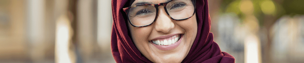 Woman wearing a red hijab and glasses smiling
